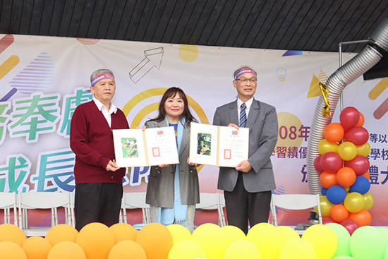 中華民國保護動物協會童麗麗副秘書長(中)回贈附有流浪動物照片的感謝狀。 姚崇仁/攝