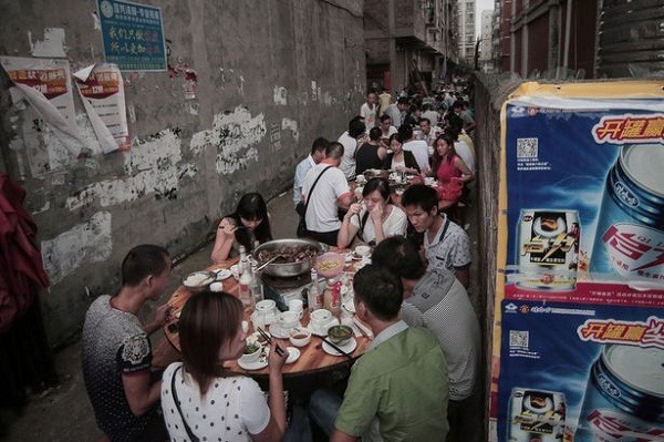 玉林狗肉節的一景，男女老少在巷弄內擺桌大啖狗肉宴席。取自網路