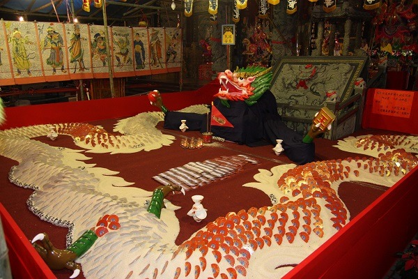 寺廟辦法會以五穀食物及其他配件打造龍的造型，豬、牛、羊等獻祭用的動物，也以造型糕餅取代活體宰殺。蕭士塔/攝