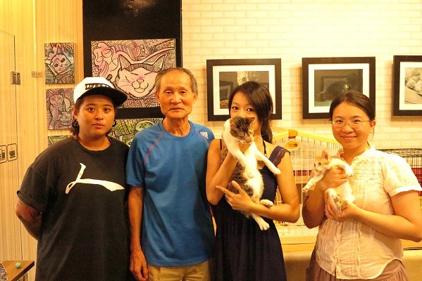動保畫家王勤靜(左起)、郭順雄理事長、主辦店家邱炤華，和參觀民眾在認養會合照。 蕭士塔/攝