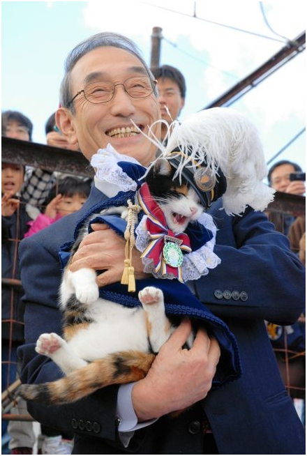 2009年，獲頒「和歌山縣勲功爵」稱號的小玉和和對牠一見鍾情的和歌山電鐵社長。 取自朝日新聞