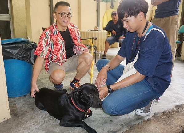 程仕吉(右)、錢亞東兩人買狗食和繩鍊前往派出所探望黑狗。蕭士塔/攝