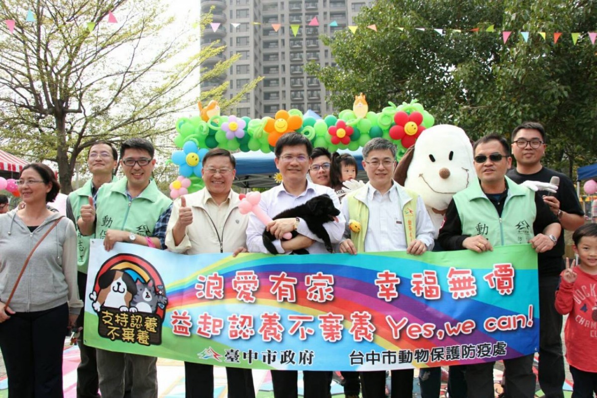 台中市長林佳龍在活動現場與動保處同仁們的大合照，你發現右後方的布偶了嗎？   台中動保處/提供