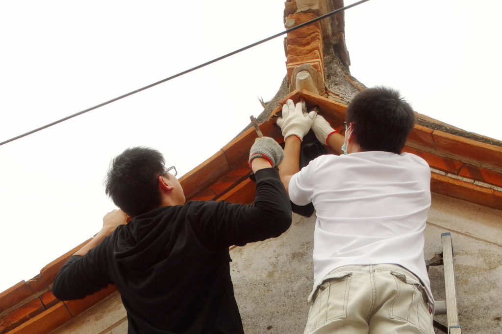 金管處同仁到現場支援，將受困的赤腹鷹從屋簷取下。　金門縣政府/提供