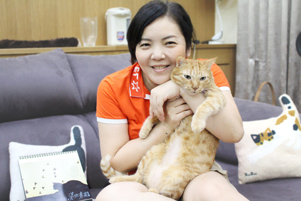 小賢抱著家中元老級愛貓，緩緩說著淡水有貓的種種。　何宜/攝