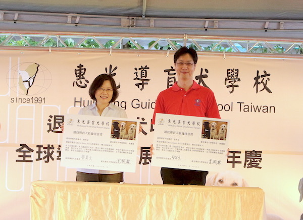 在眾人面前完成退役導盲犬收養同意書的簽署儀式。   何宜/攝