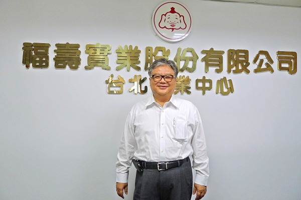 福壽實業董事長洪堯昆，介紹福壽飼料所採用之非基改玉米。　何宜/攝