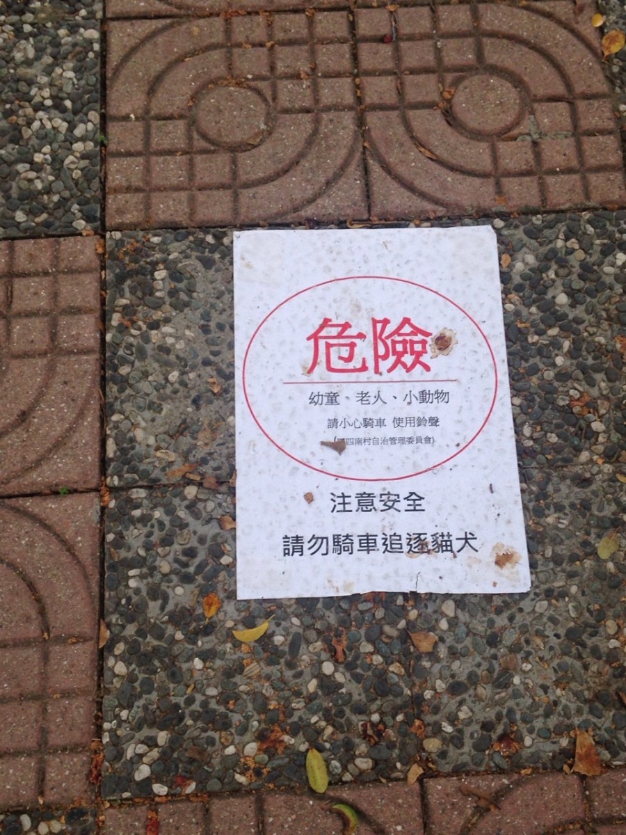 四四南村有提醒自行車放慢車速的標語,希望能保障小孩、老人及動物的安全。 何宜/攝