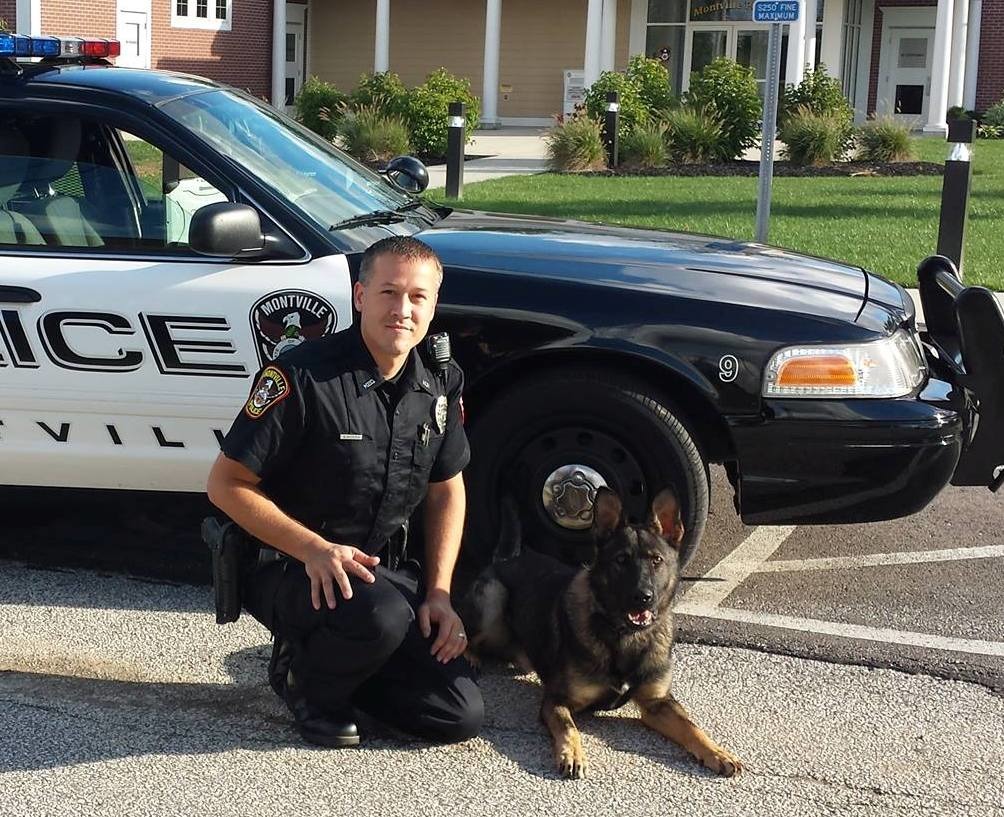 警官哈里森與警犬班尼合影,哈里森因去年將班尼獨留車中中暑死亡,而遭法官審判。 取自medinagazette