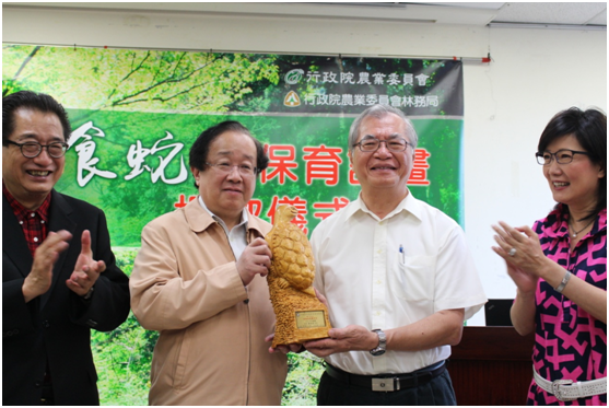 局長李桃生致贈以漂流木雕刻的食蛇龜塑像給潘思源。　何宜/攝