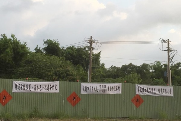 嘉義市新建流浪犬收容中心遭到鄰近寺廟廟方反對，預定地還被拉起白布條抗議。　嘉義市動物守護協會/提供