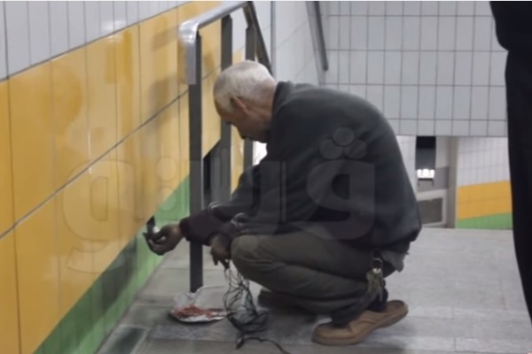 在開羅一處地鐵站外經營眼鏡行的阿卜杜,天天餵食住在牆縫內的貓咪,即使遇上革命,5年來從不間斷。 取自Youtube