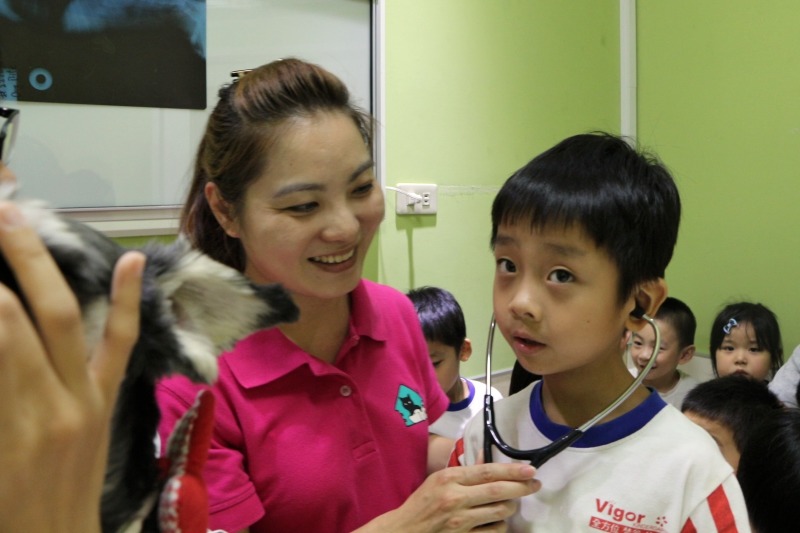 小朋友用聽診器聆聽狗兒心跳聲,感受生命的力量。 全國動物醫院連鎖體系/提供