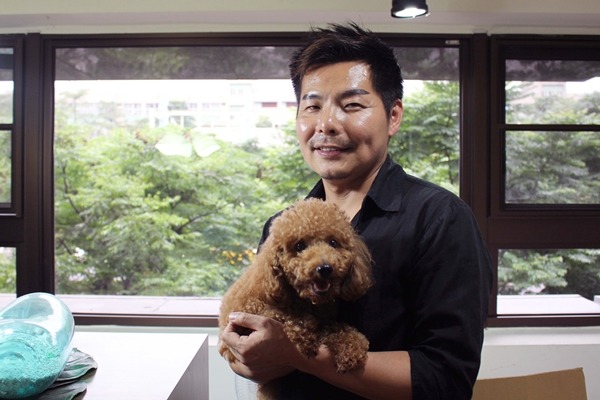 集賢愛生動物醫院院長楊振墉養了3隻米克斯,院內有狗兒需要輸血時,便出動自家愛犬捐血。圖中的貴賓是即將出院的狗兒。 江幸芸/攝