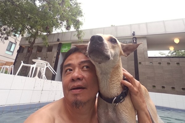 30年狗奴楊杰承習慣在車上放飼料，看到浪犬就餵食，也因此收編了6隻狗兒。圖為楊杰承與YOYO。　楊杰承/提供