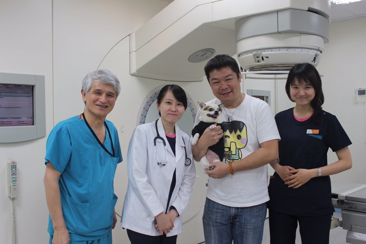 中臺科大「動物放射治療研究中心」醫療團隊與「喜兒」及爸爸的合照。中臺科技大學/提供