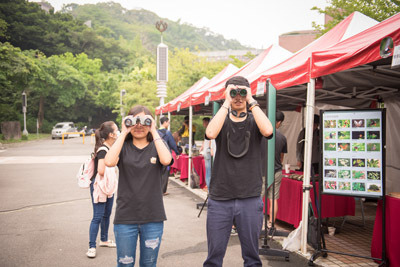 參觀大葉大學生資系展覽的學生體驗望遠鏡觀察。大葉大學/提供