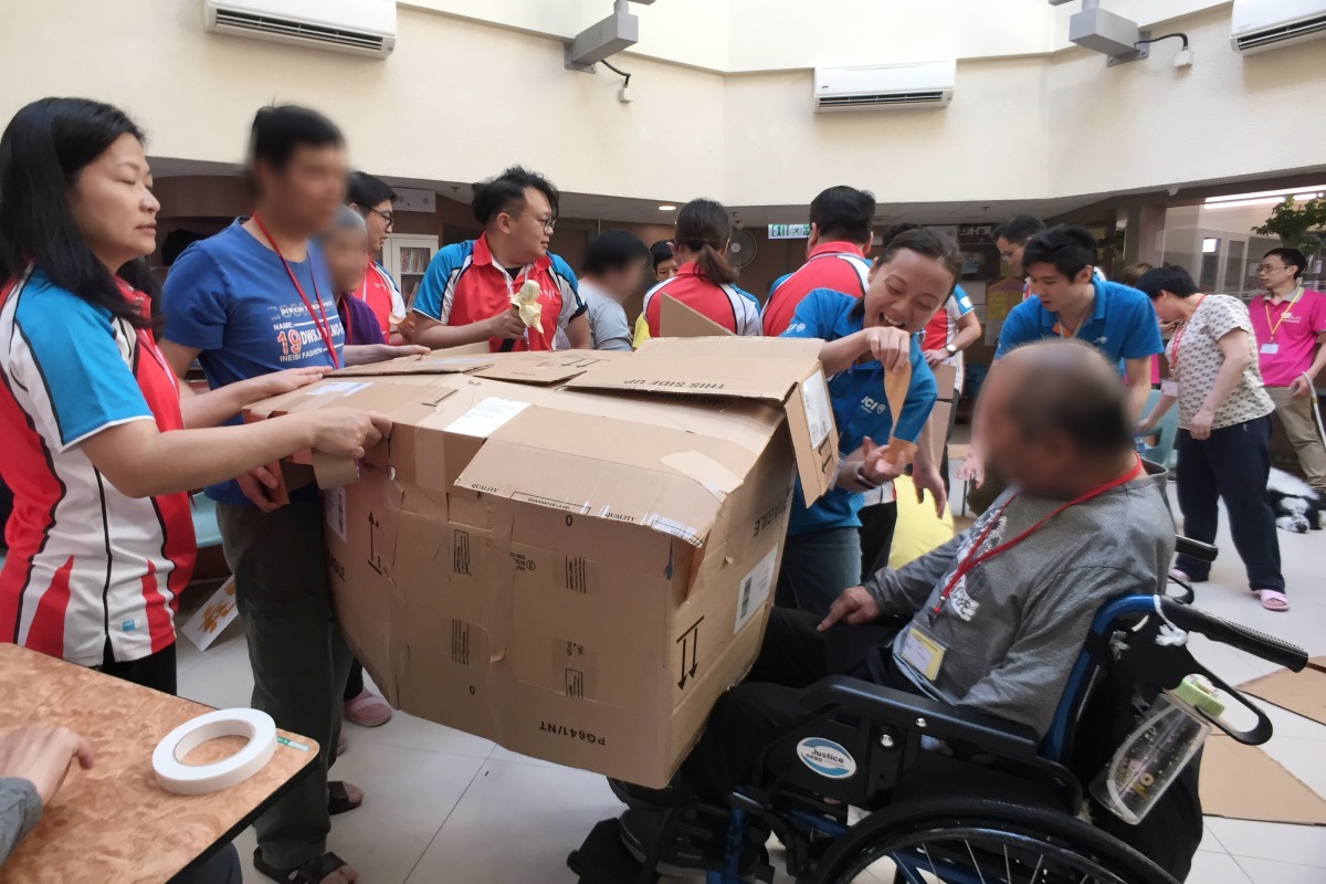 義工為使所有學員能夠參與，特意拿高狗屋方便學員。海港青年商會/提供