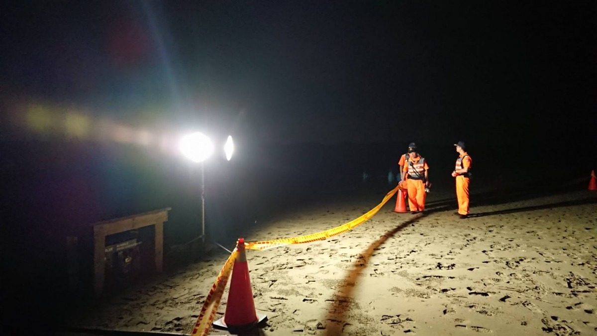 海巡署人員拉起警戒帶，封鎖管制，並協助挖洞掩埋。圖／台南市動保處提供