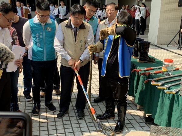 黃市長在專業人員戒護下體驗抓蛇。圖／台南市消防局提供