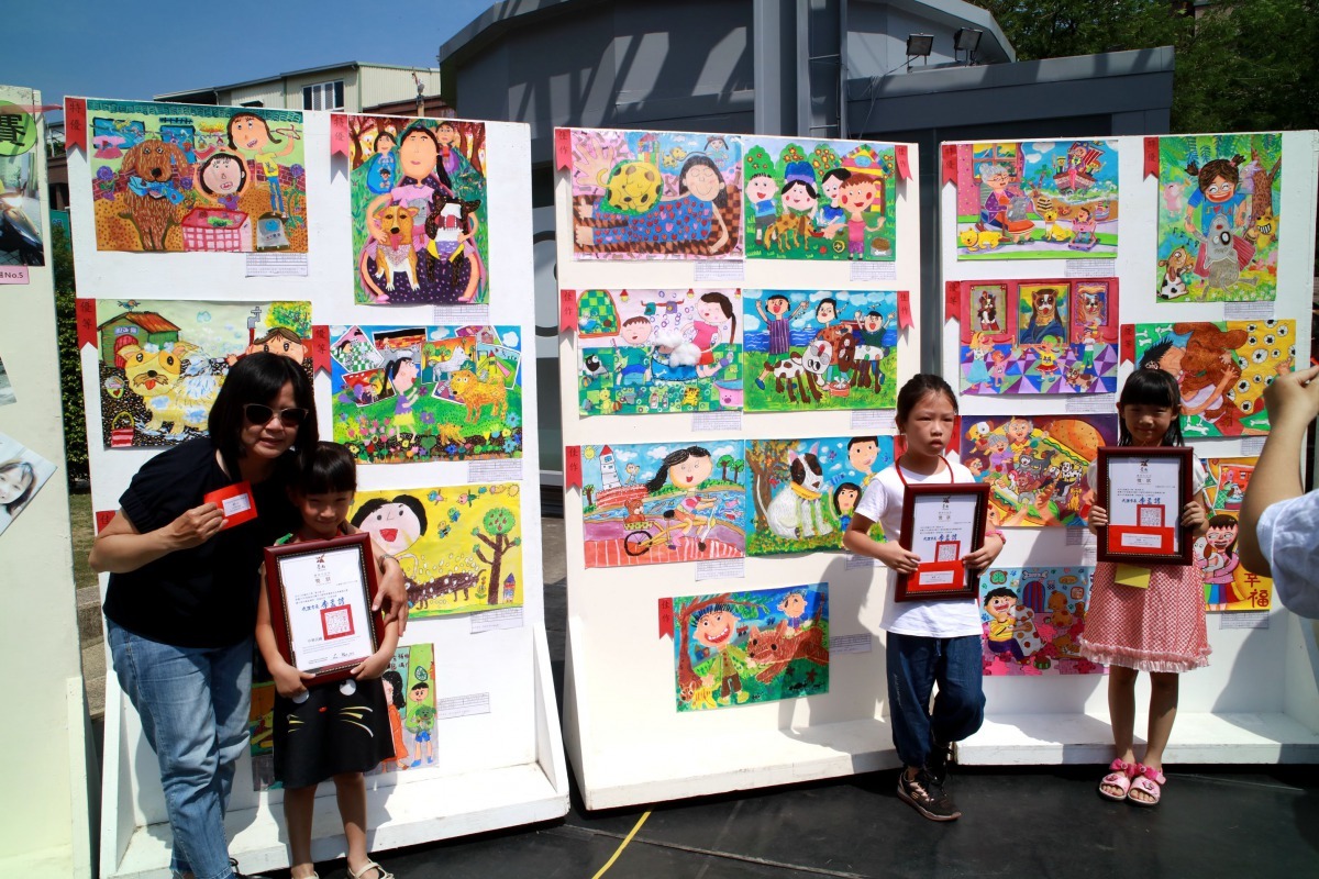 去年得獎學生和家長與得獎作品合影留念。圖／台南市動保處提供