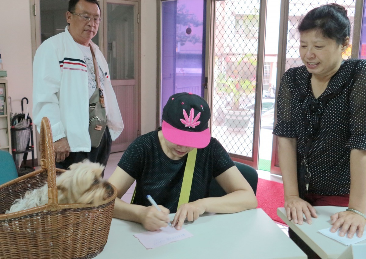 民眾(右)拾獲犬隻送到動保處，依晶片資料找通知焦急的失主。高維奇/攝