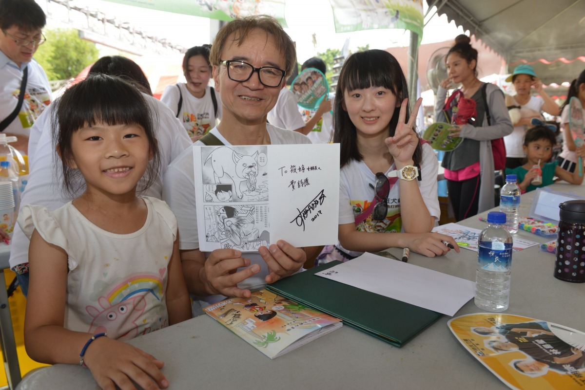 參加著色比賽的小學生要求菅谷充在畫作上簽名。高維奇/攝