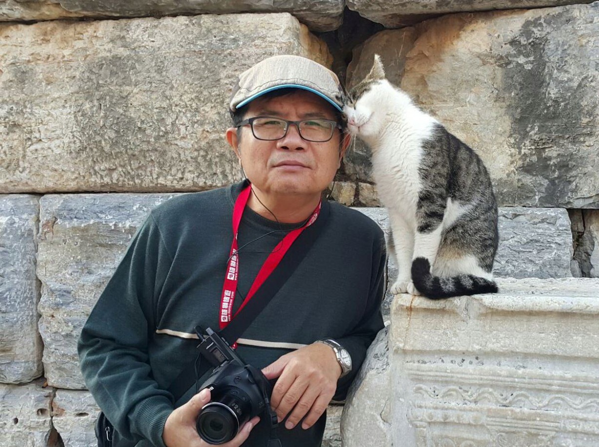 這隻貓向合照的遊客撒嬌磨蹭，引來許多人圍觀拍照。高維奇/攝