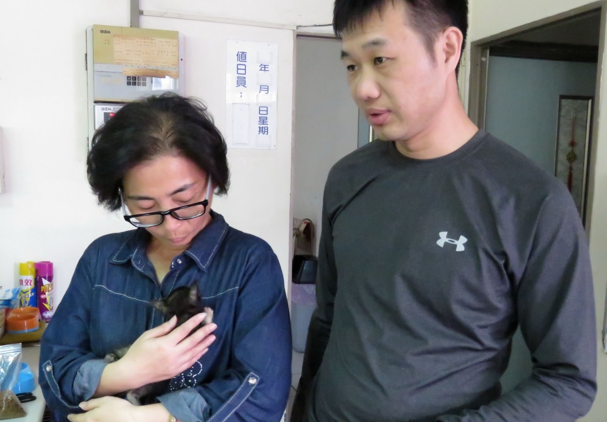 Lucky送養者(左)與認養者到動保處辦理認養手續。高維奇/攝