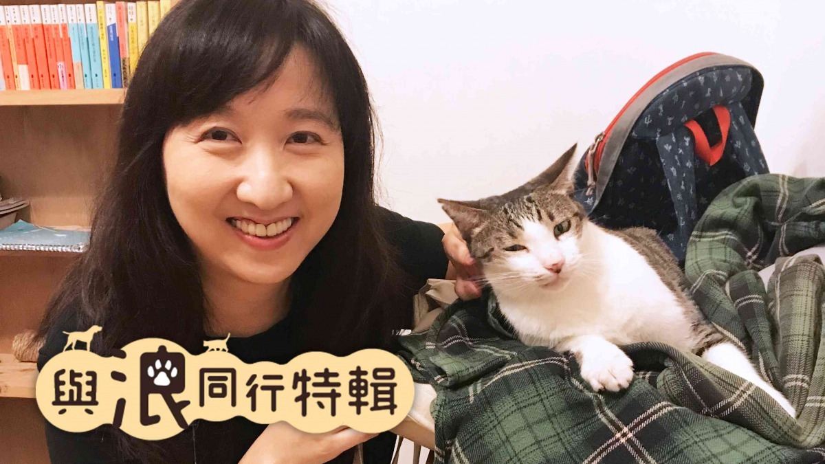 黃宗慧投身動保教育與倡議十數年，努力與公眾溝通動物權。圖為黃宗慧在時光1939書店與店貓白肚共同燦笑合影。（圖片／黃宗潔攝）