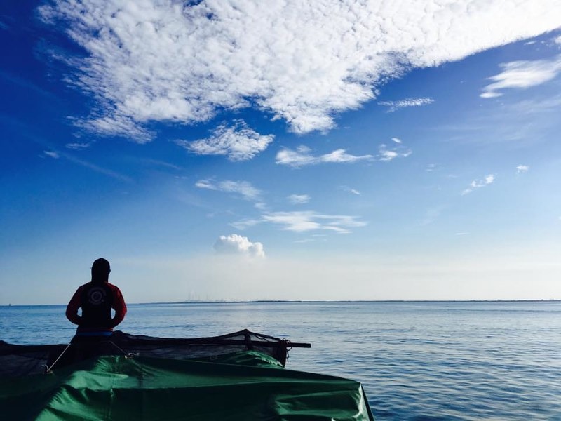 隨船出海中,望向台塑麥寮工業區的海洋哺乳動物觀察員。潘佳修攝。