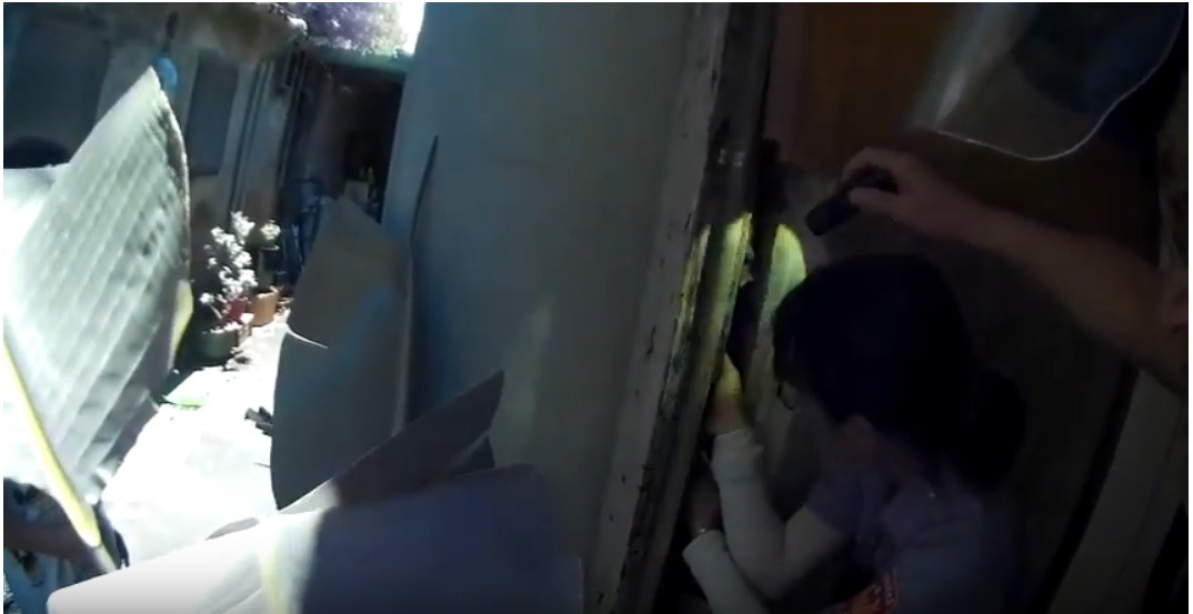 員警發現小貓卡在狹小的牆壁縫中,試圖將手掌伸進去救援。雨林/翻攝