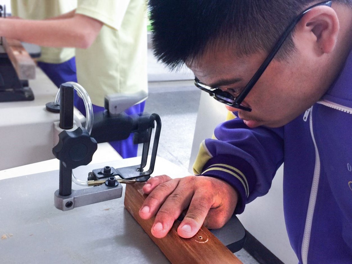 同學全神貫注的在木工教室內雕琢。台北市福安國中/提供