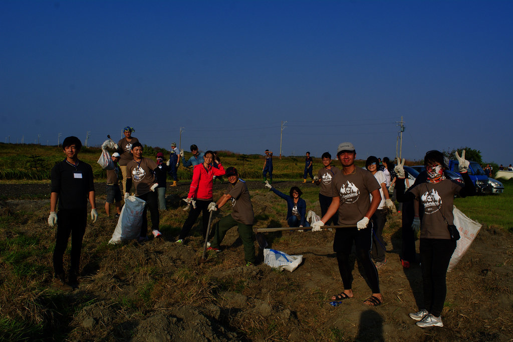 志工們於海邊的烈日與狂風下清除雜草。攝影:洪碩辰。