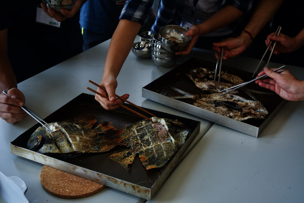 志工迫不及待品嚐新鮮海鮮。攝影:洪碩辰。