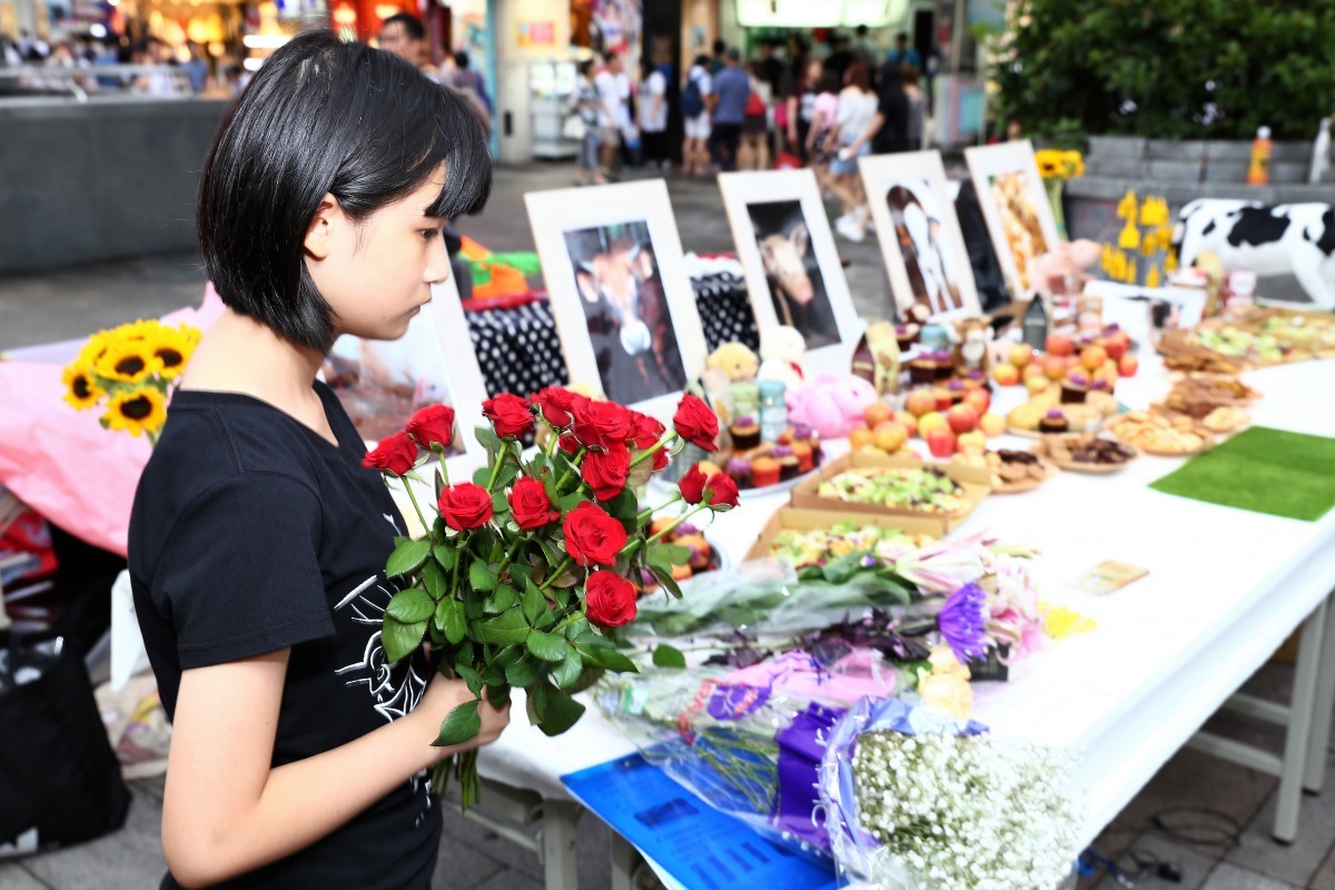 民眾身穿黑衣、手持紅玫瑰，表達對逝去動物的悼念與祝福。雨林/翻攝