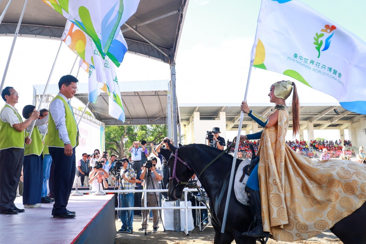 林市長從從騎師手中接下花博旗幟-帶領志工宣誓。台中觀旅局/提供