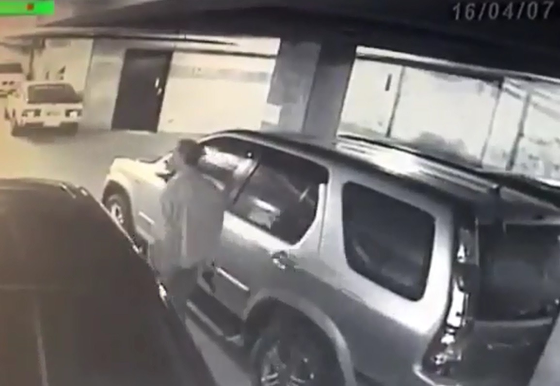 停車場監視畫面中,可看見男子手持不明槍枝不斷巡視。 影片截圖,許先生/提供