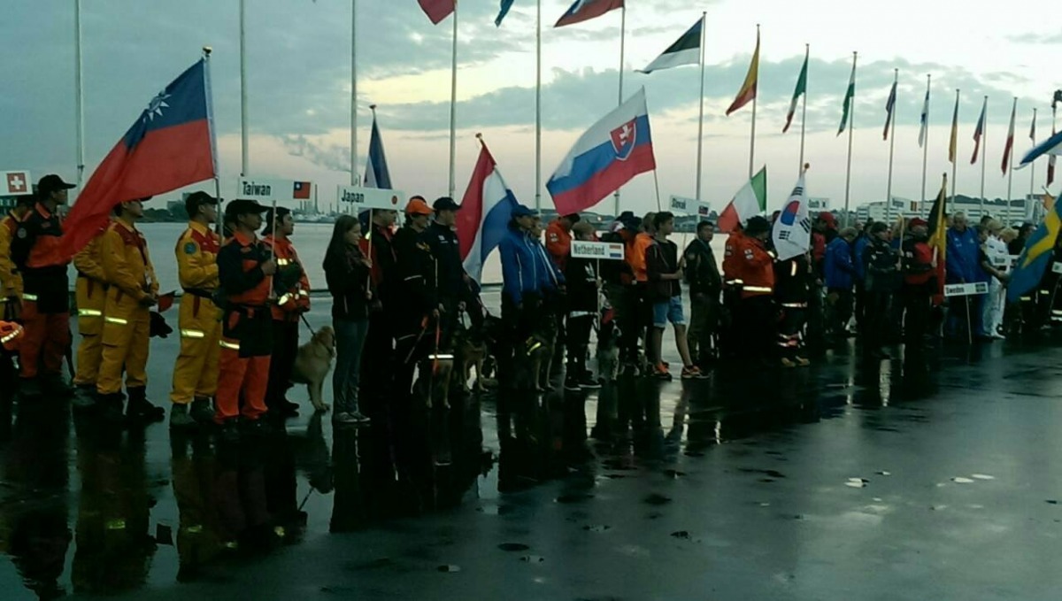 搜救犬台灣代表隊於丹麥高舉國旗。 台北市陪伴犬協會/提供