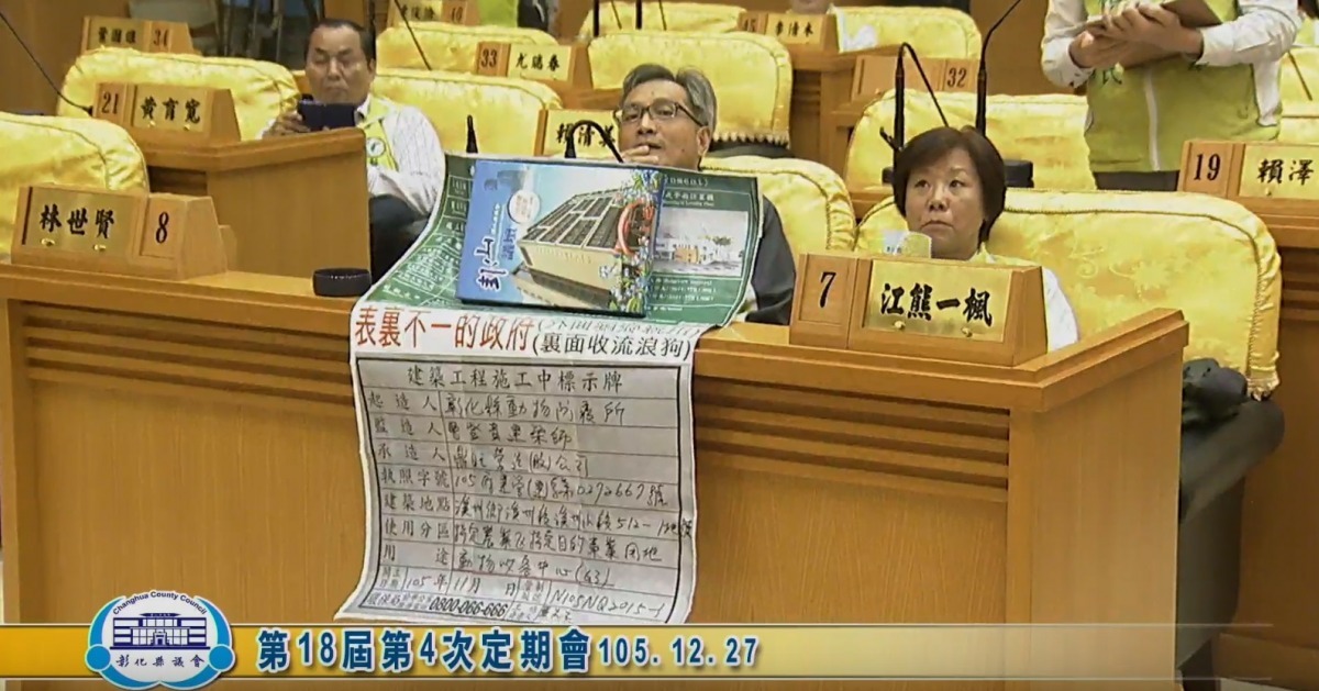 江熊一楓27日攜帶一張「民眾製作」的海報出席三讀會，質疑可愛動物教育園區的命名會誤導民眾。　彰化縣議會議事線上直播截圖