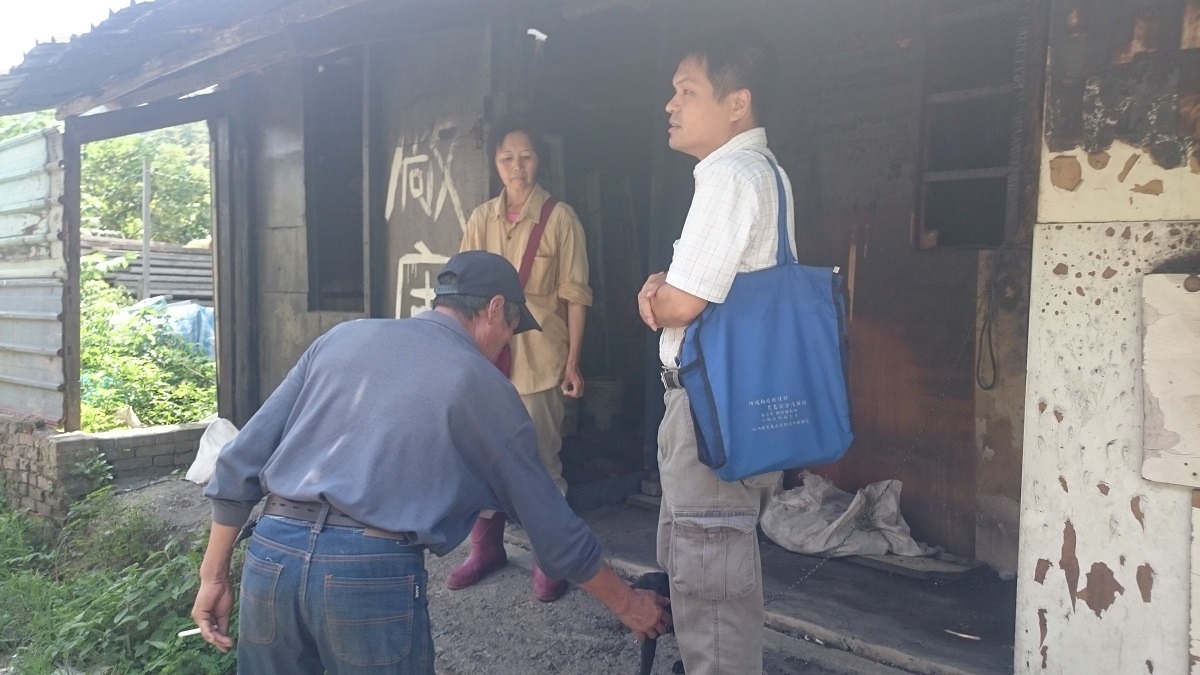 基隆市義務動保員婁欣（黃衣）與防疫所所長陳瑞濱（右）前往通報地點查看犬隻狀況，戴帽者為當地民眾，非原飼主。　　基隆防疫所/提供