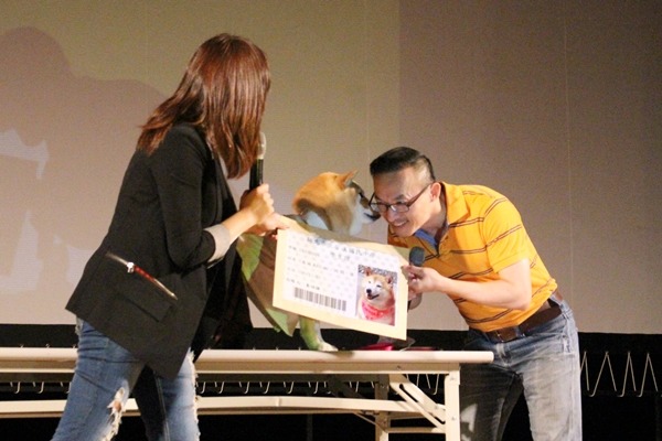 安溪國中校長簡財源（右）頒發學生證給TVBS主播秦綾謙（左）的愛犬由美。　江幸芸/攝