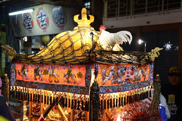 神明雞到晚上還站在神轎，廟方表示當天共準備３隻雞輪流站轎。民俗攝影師/提供