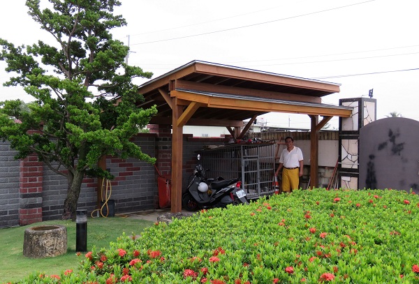 以原木興建的犬舍，能替狗籠遮風避雨，前面還有一棵羅漢松可擋陽光，畫面是不是美觀極了!  蕭士塔/攝