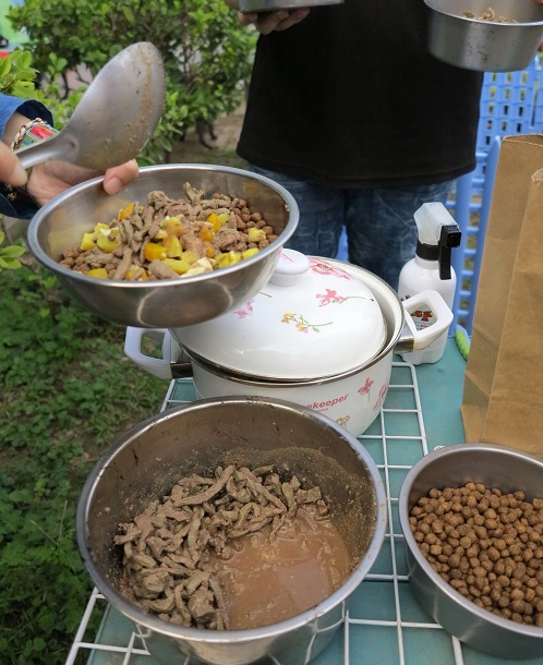 莊華亭向傳統市場攤商勸募豬肝，煮熟後帶到收容所為病弱犬隻補充營養。蕭士塔/攝