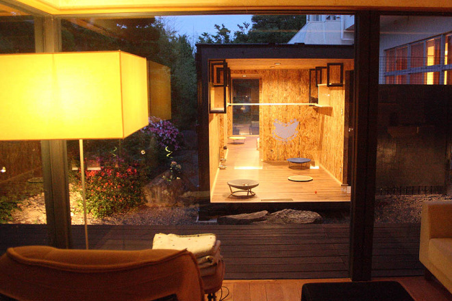 「貓庭」面向旅館大廳的那一側安裝大片落地窗,住宿客可以一邊坐在沙發上休息,一邊眺望可愛的貓咪們。 取自手島旅館