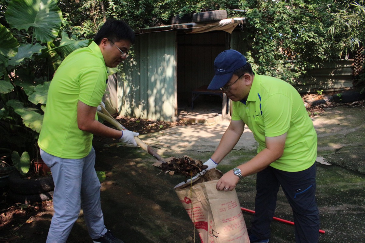 英特威公司員工幫忙打掃保育場的落葉。攝影/朱曼寧