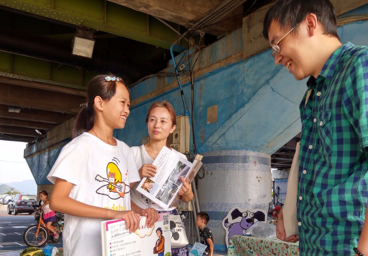 張小妹妹與媽媽一起擔任志工，向民眾宣導如何與流浪動物互動。陳璽安/攝