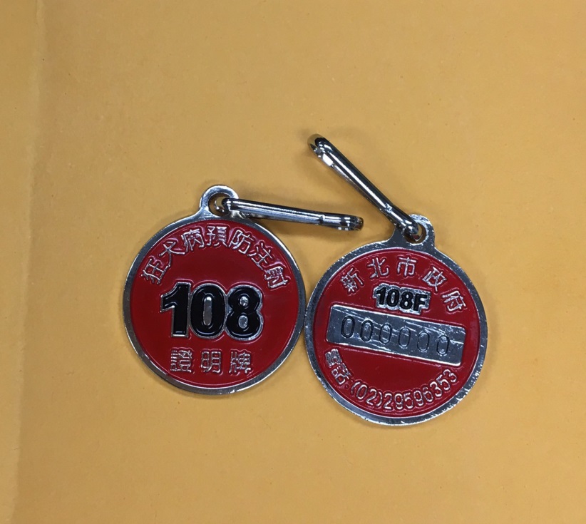 今（108）年度的頸牌為亮眼的「朱紅色」，圖為108年度狂犬病頸牌打樣本。新北市動保處/提供