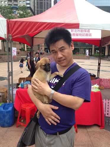 由媒體得知活動消息，前來認養的新北市民鄧先生與小黃狗。何宜/攝